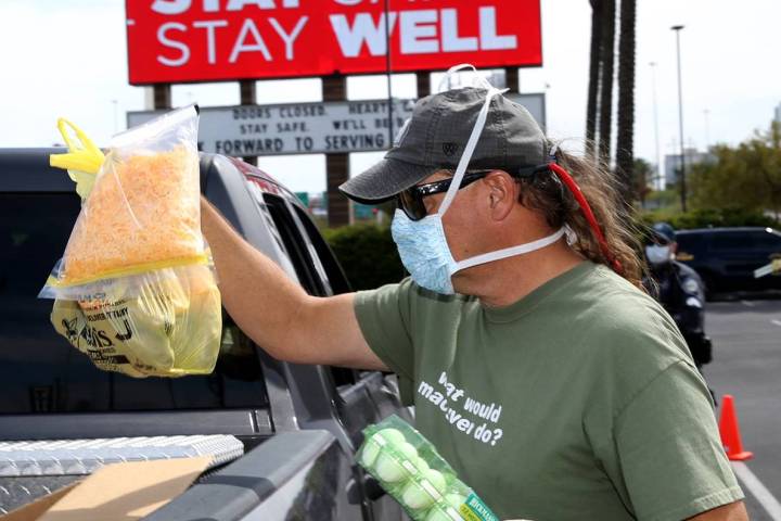Brian Fisher, 53, of Las Vegas helps distribute food at Palace Station in Las Vegas Thursday, A ...