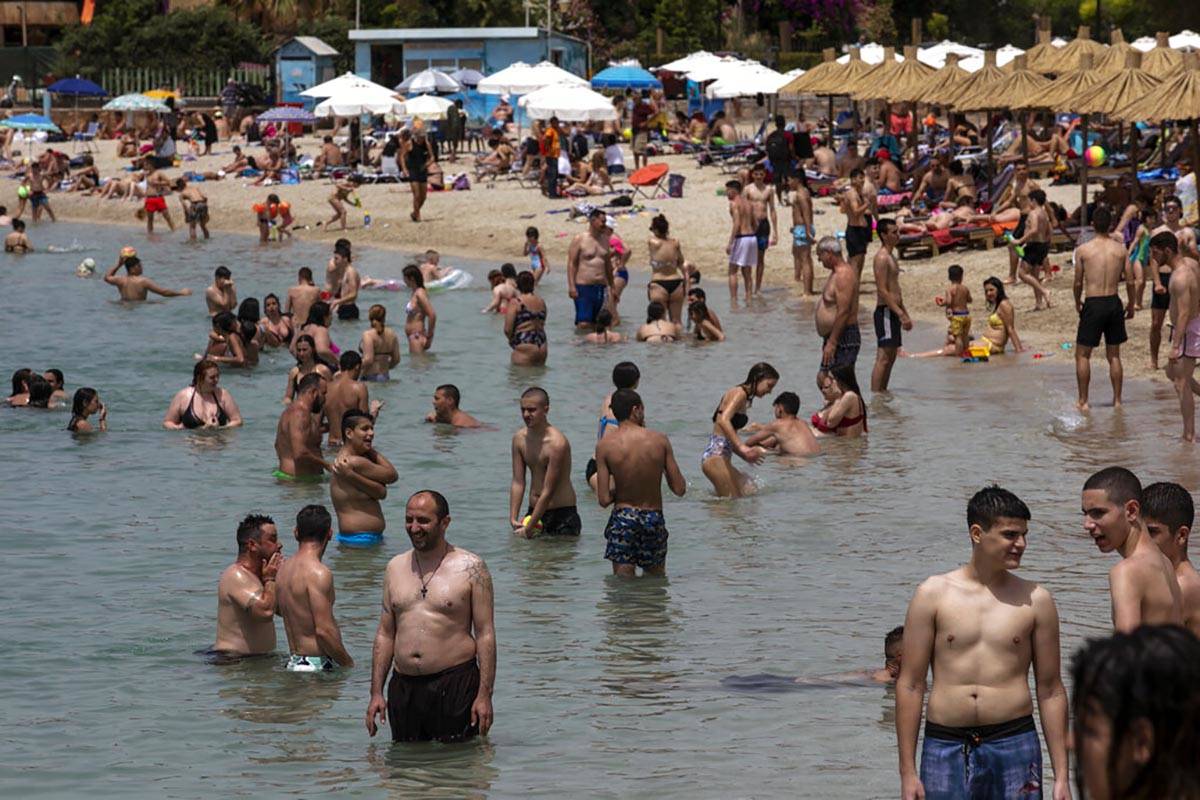 Swimmers enjoy the sea at an open to the public beach, at Alimos suburb, near Athens, on Saturd ...