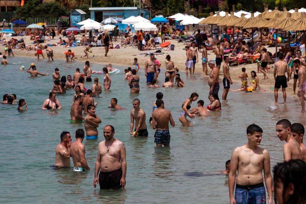 Swimmers enjoy the sea at an open to the public beach, at Alimos suburb, near Athens, on Saturd ...