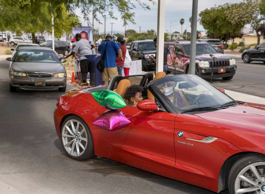 Drivers navigate past the reception area during a mail ballot drop-off parade at the at the U.S ...