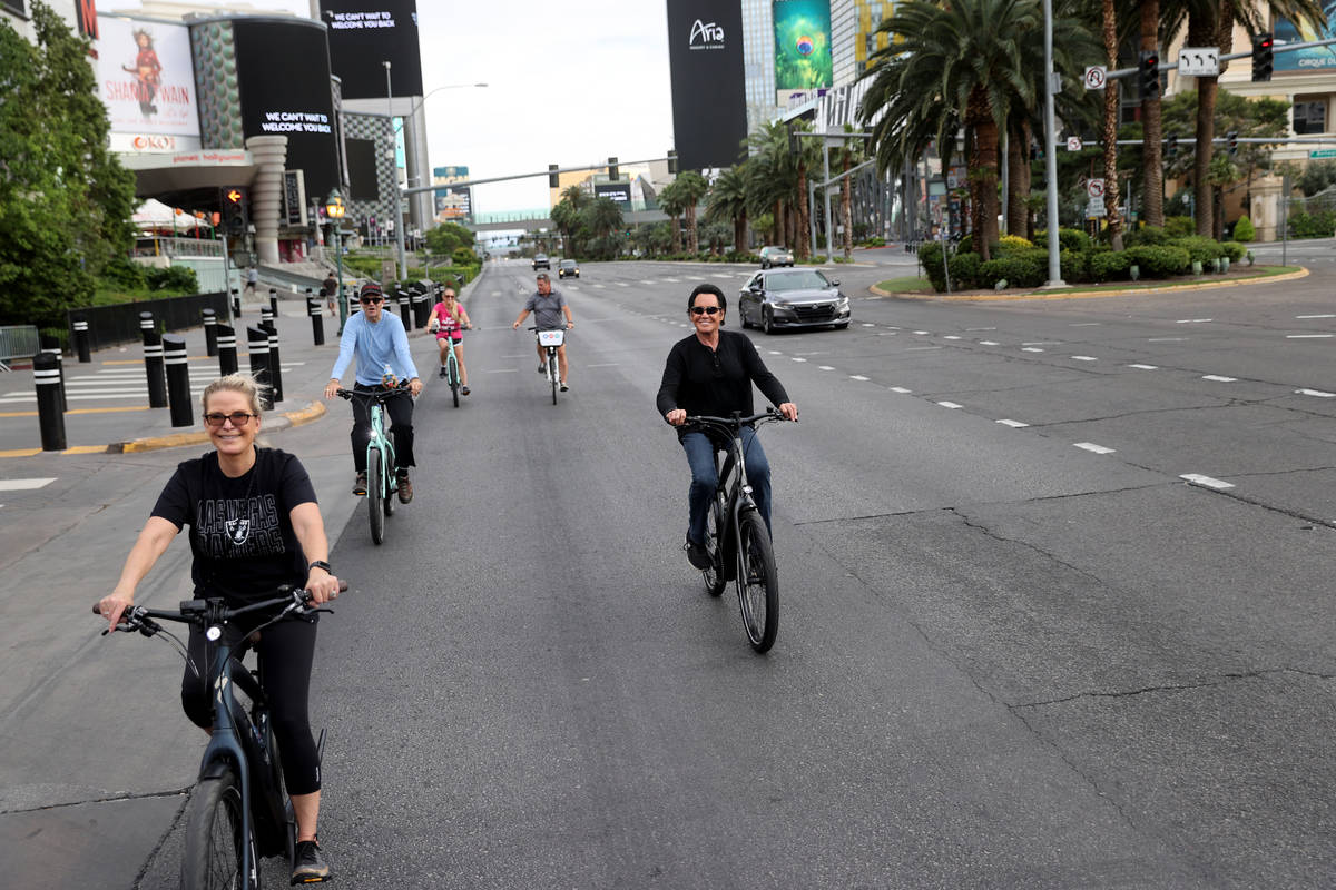 Mr. Las Vegas Wayne Newton, right, rides a bicycle on the Strip in Las Vegas with, from left, w ...