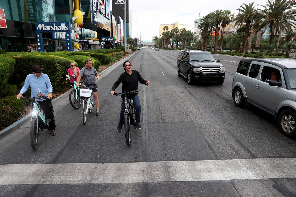 Mr. Las Vegas Wayne Newton, right, acknowledges fans while riding a bicycle on the Strip in Las ...