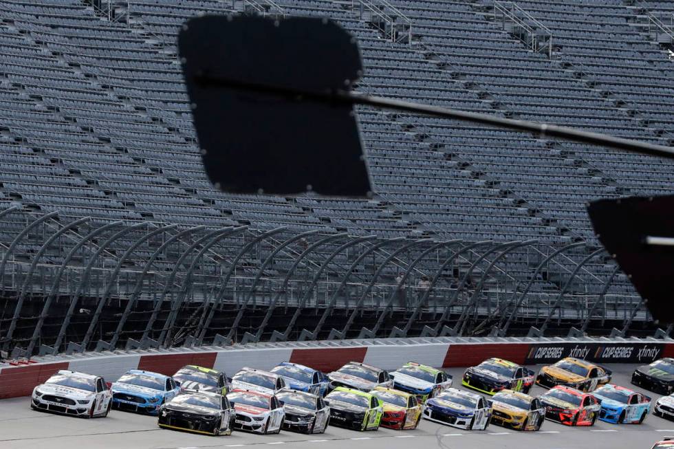 Cars approach the starting line in front of empty stands to start the NASCAR Cup Series auto ra ...