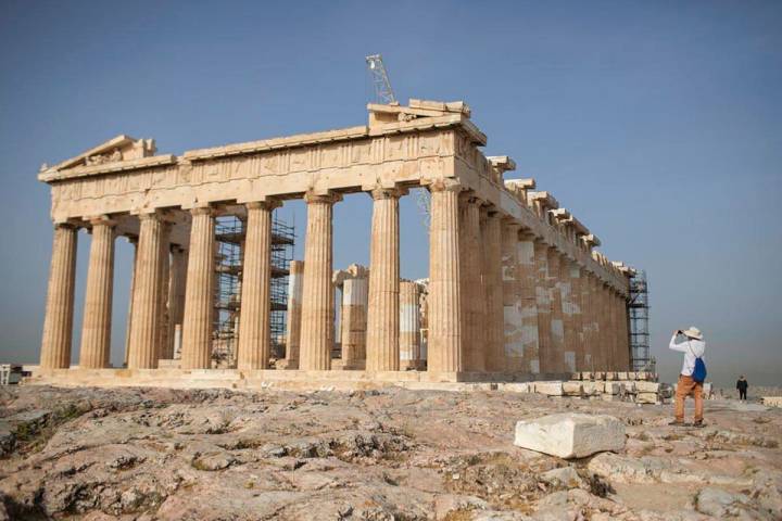 A man takes a picture next the ancient Parthenon temple at the Acropolis hill of Athens, on Mon ...