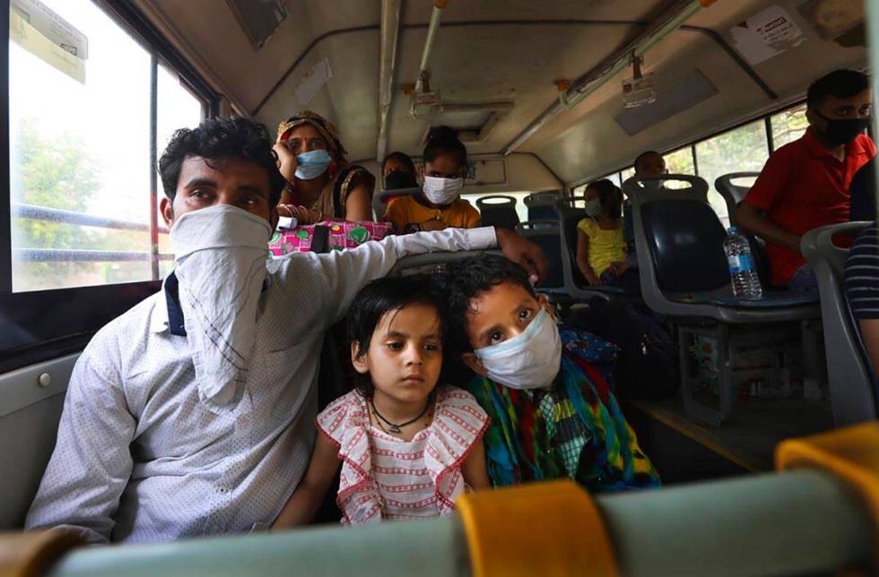 A migrant family from another state trying to return to their villages waits in bus to be trans ...