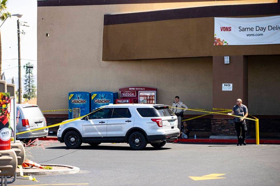 A man is detained as Las Vegas police investigate the scene of a shooting at Tropicana Avenue a ...