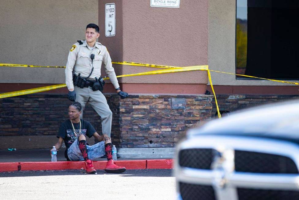 A man is detained as Las Vegas police investigate the scene of a shooting at Tropicana Avenue a ...