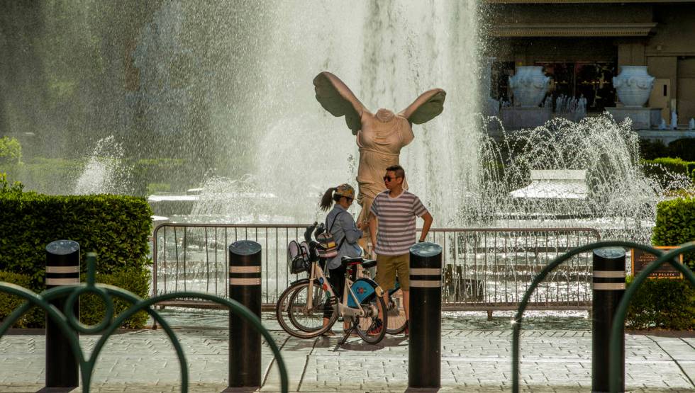 Cyclists pause to view the main Caesars Palace fountain area now back in operation on Monday, M ...