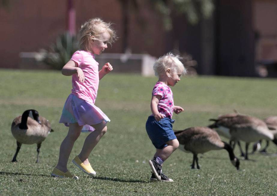 Evelyn McClellan, left, 3, and her 18-month-old sister, Emery, play at Cornerstone Park on Tues ...
