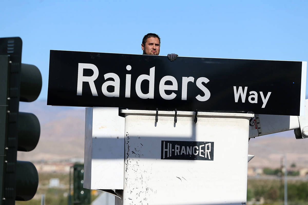 Adam Anderson, a driver traffic signal technician for the city of Henderson, installs a Raiders ...