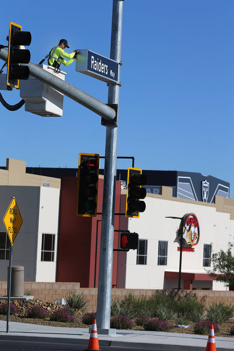 Justin Buhl, a traffic signal technician for the city of Henderson, installs a Raiders Way stre ...