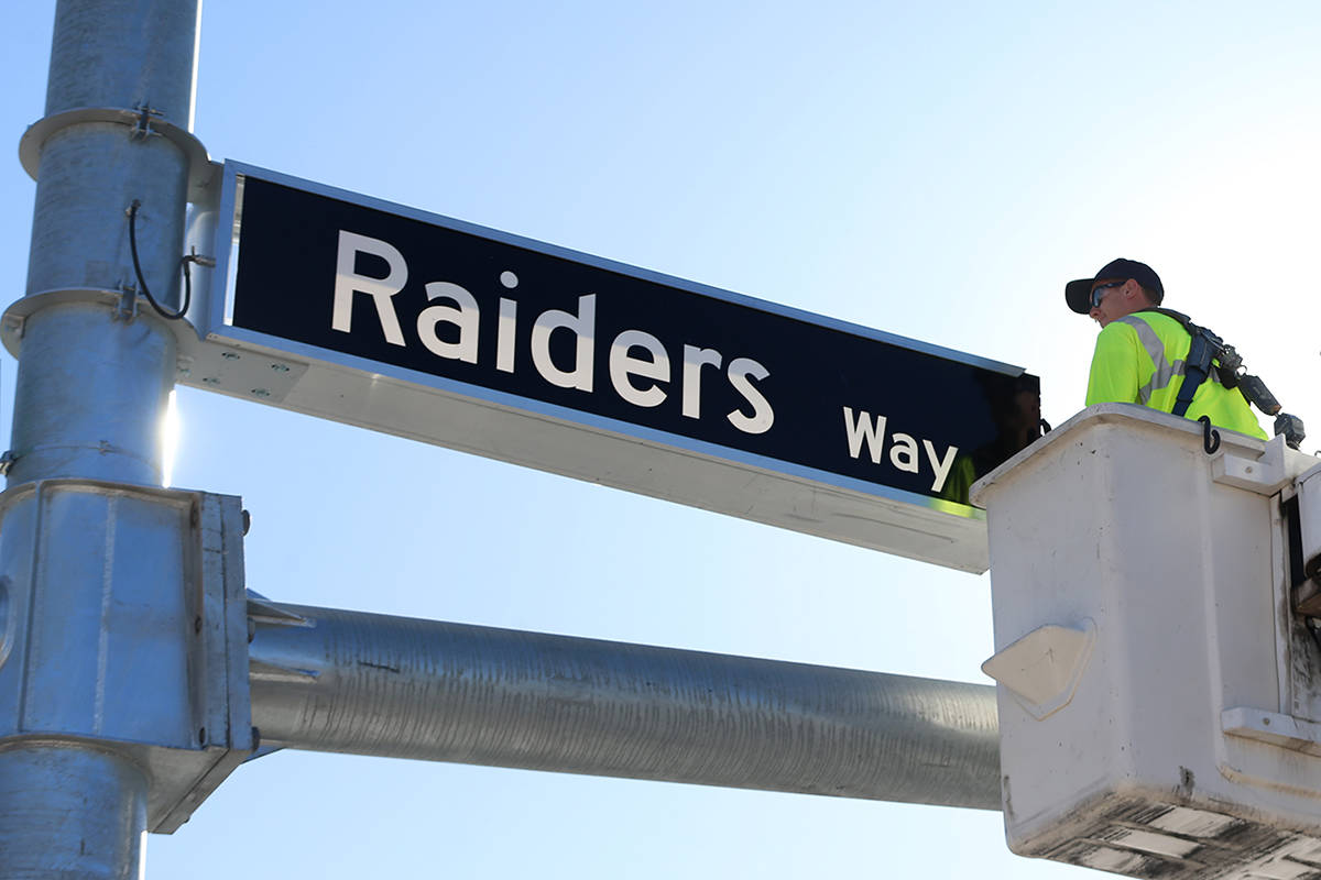 Justin Buhl, traffic signal technician for the city of Henderson, installs a Raiders Way street ...
