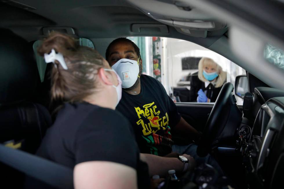 Kerri Sims, left, and Christopher McCall of Las Vegas lean in to kiss each other while wearing ...