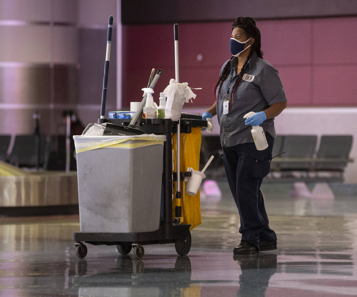 Cleaning staff work in the baggage claim area at McCarran International Airport on Wednesday, M ...