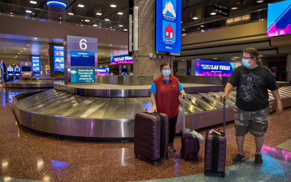 Susan Yowell and husband Jack gather her luggage after arriving at the Terminal 1 baggage claim ...