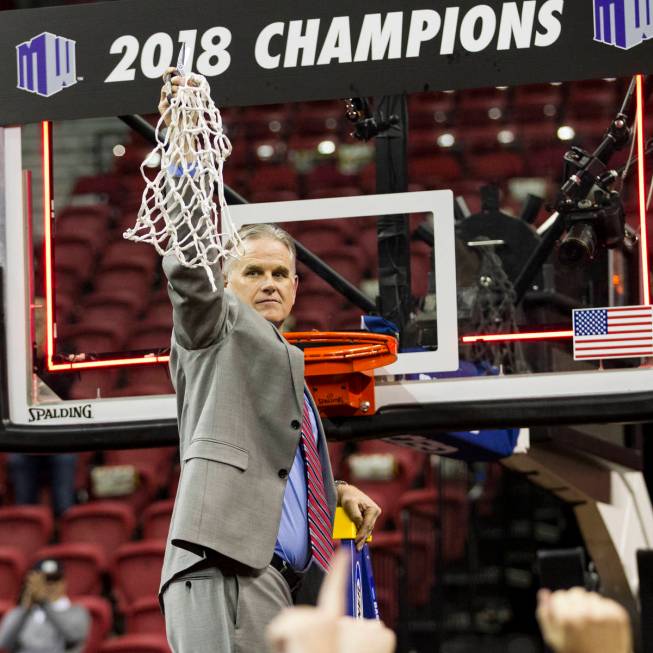 San Diego State Aztecs head coach Brian Dutcher after cutting down the net following a win agai ...