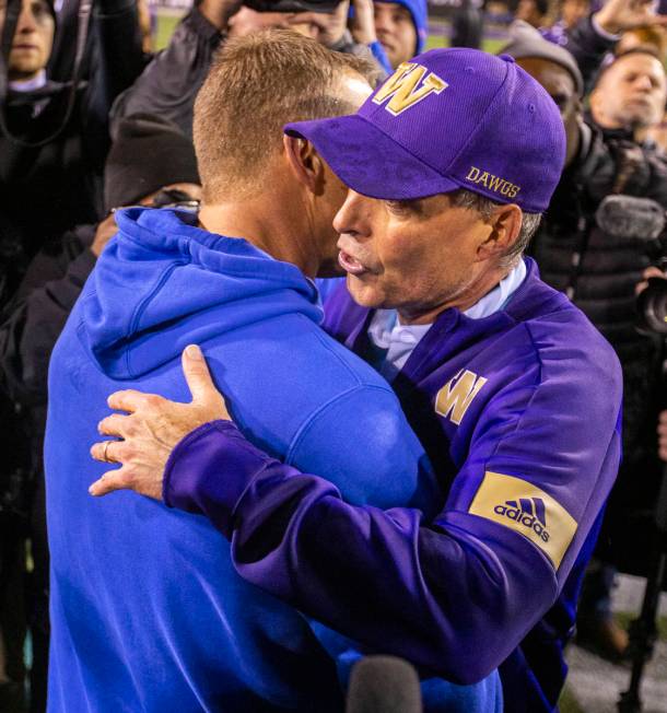 Boise State Broncos head coach Bryan Harsin, left, embraces Washington Huskies head coach Chris ...