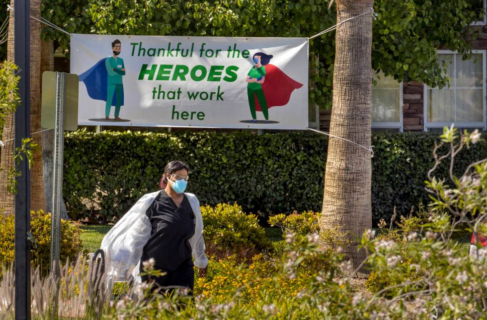 A woman walks out of The Heights of Summerlin, which has had numerous deaths there due to COVID ...