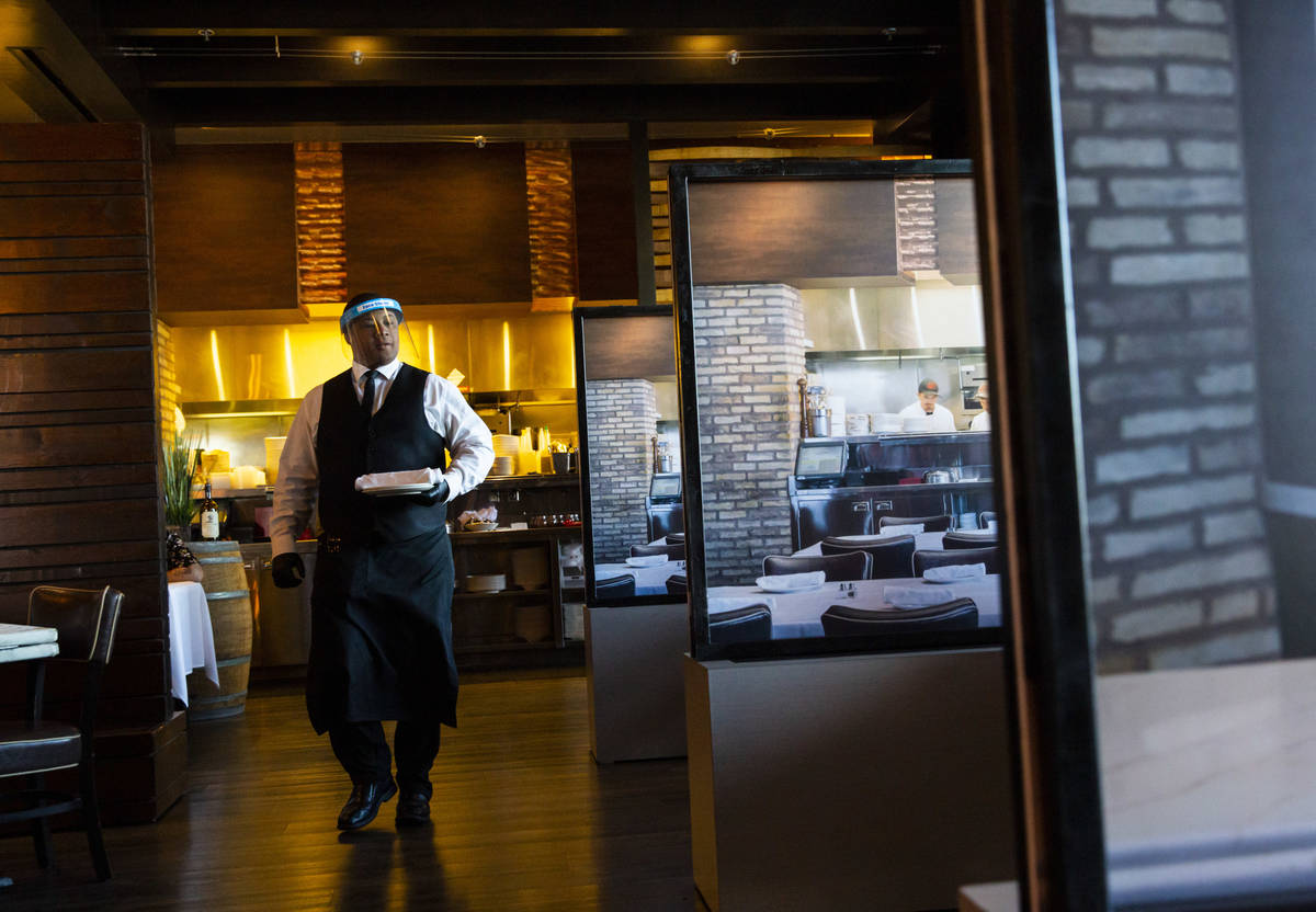 Donald Bailey wears a face shield while serving diners at Nora's Italian Cuisine in Las Vegas o ...