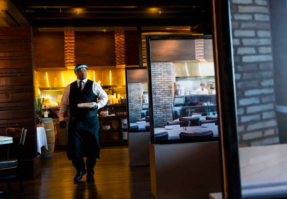 Donald Bailey wears a face shield while serving diners at Nora's Italian Cuisine in Las Vegas o ...