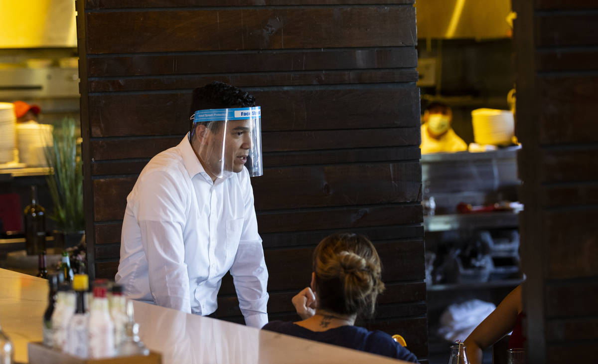 Ramon Mora wears a face shield while serving diners at Nora's Italian Cuisine in Las Vegas on T ...