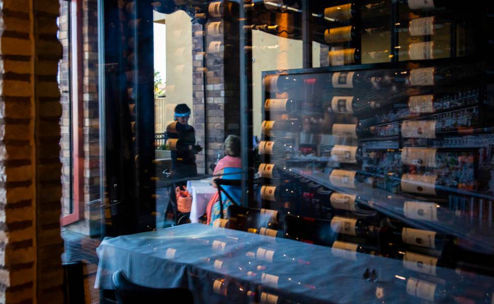 A server wears a face shield while helping diners at Nora's Italian Cuisine in Las Vegas on Thu ...