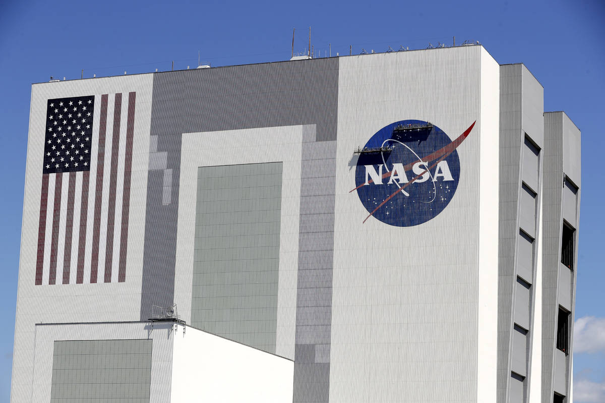 Workers near the top of the 526 ft. Vehicle Assembly Building at the Kennedy Space Center spruc ...