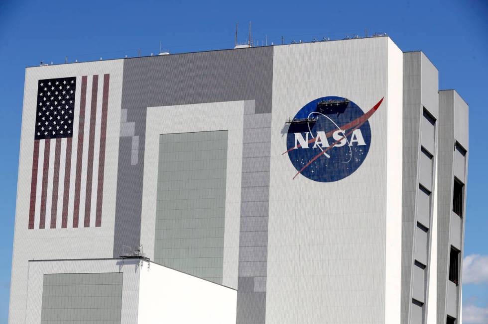 Workers near the top of the 526 ft. Vehicle Assembly Building at the Kennedy Space Center spruc ...