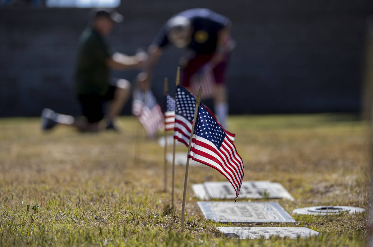 Frank Friedlander, left, and father Mort team up to plant more American flags on veteran's grav ...