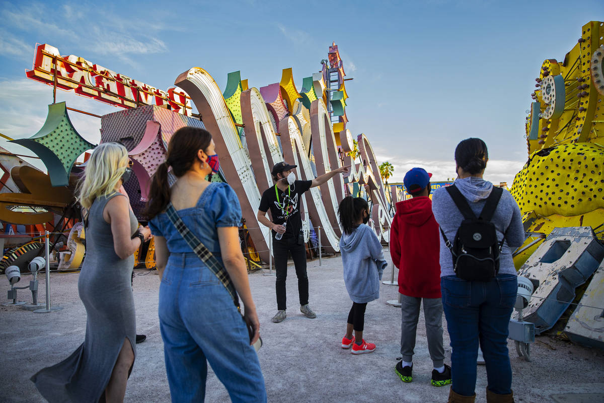 Interpreter Tyler Tingey, middle, leads a tour at The Neon Museum on Friday, May 22, 2020, in L ...