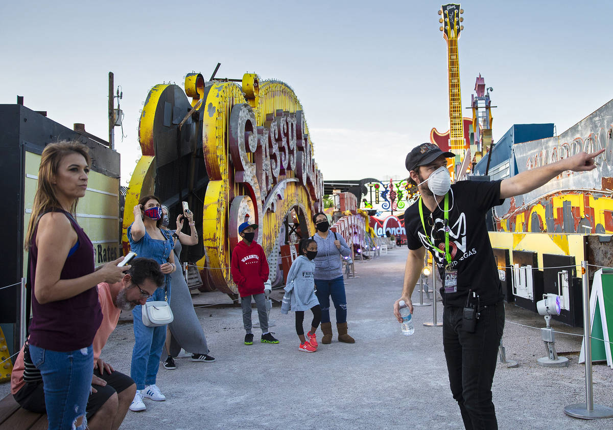 Interpreter Tyler Tingey, right, leads a tour at The Neon Museum on Friday, May 22, 2020, in La ...