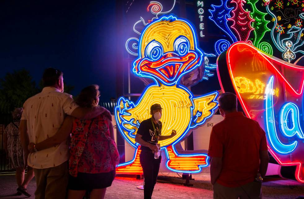 Interpreter Tyler Tingey, middle, leads a tour at The Neon Museum on Friday, May 22, 2020, in L ...