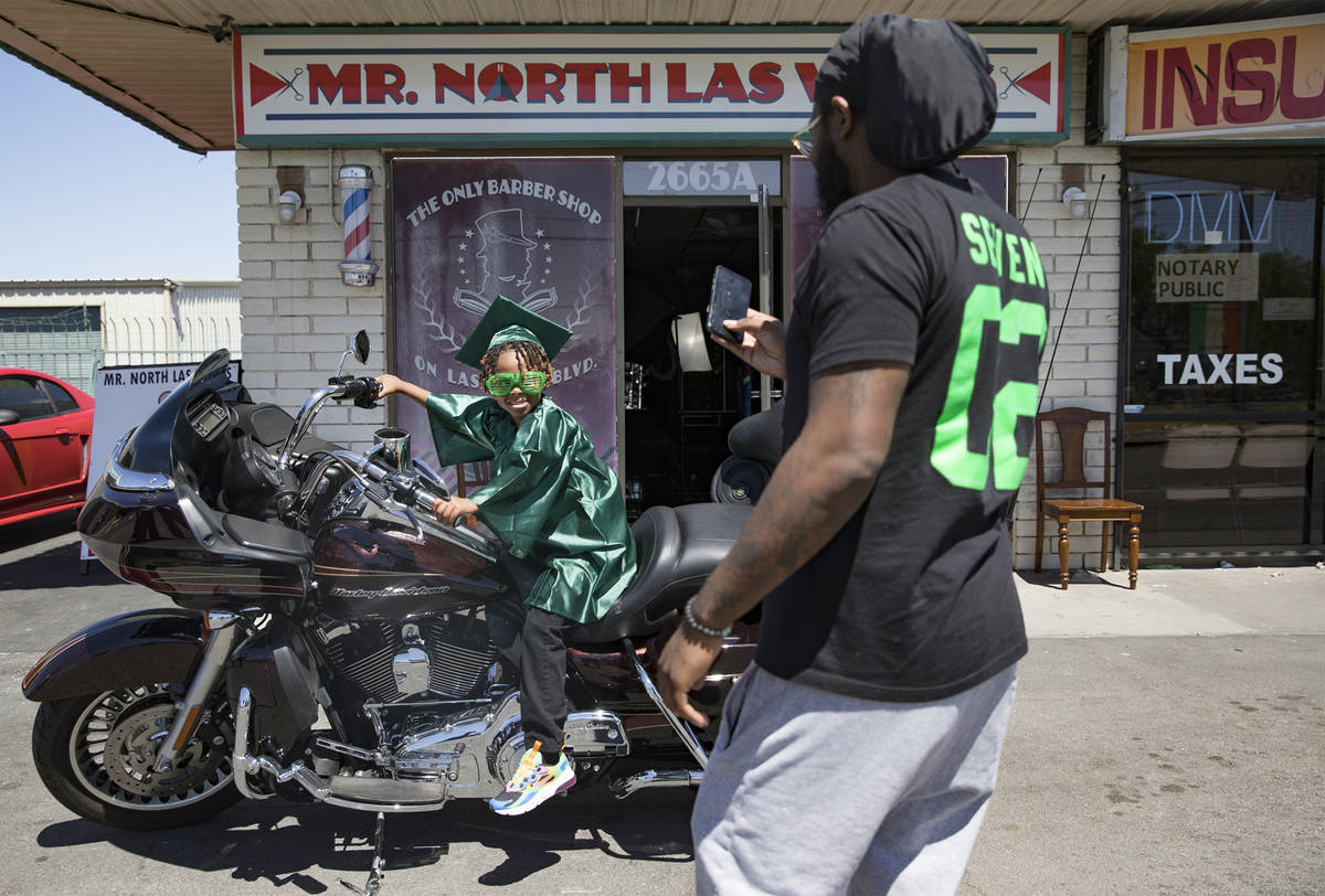 Morgan Harris takes a photo of his son Messiah Harris, 6, after having his kindergarten graduat ...