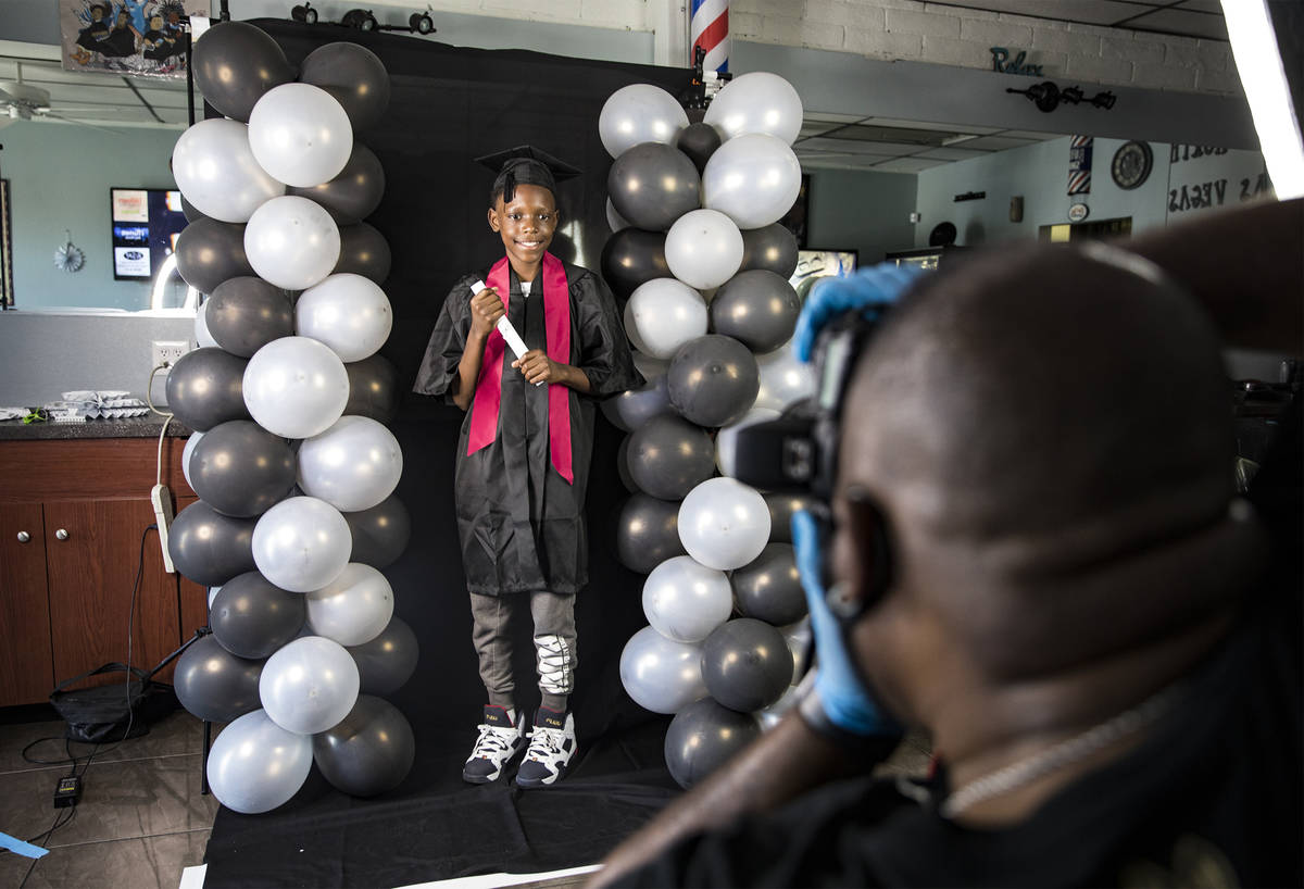 Dr. Dillard A. Scott takes a photo of Tysean Groce, 11, for his 5th graded graduation at Mr. No ...