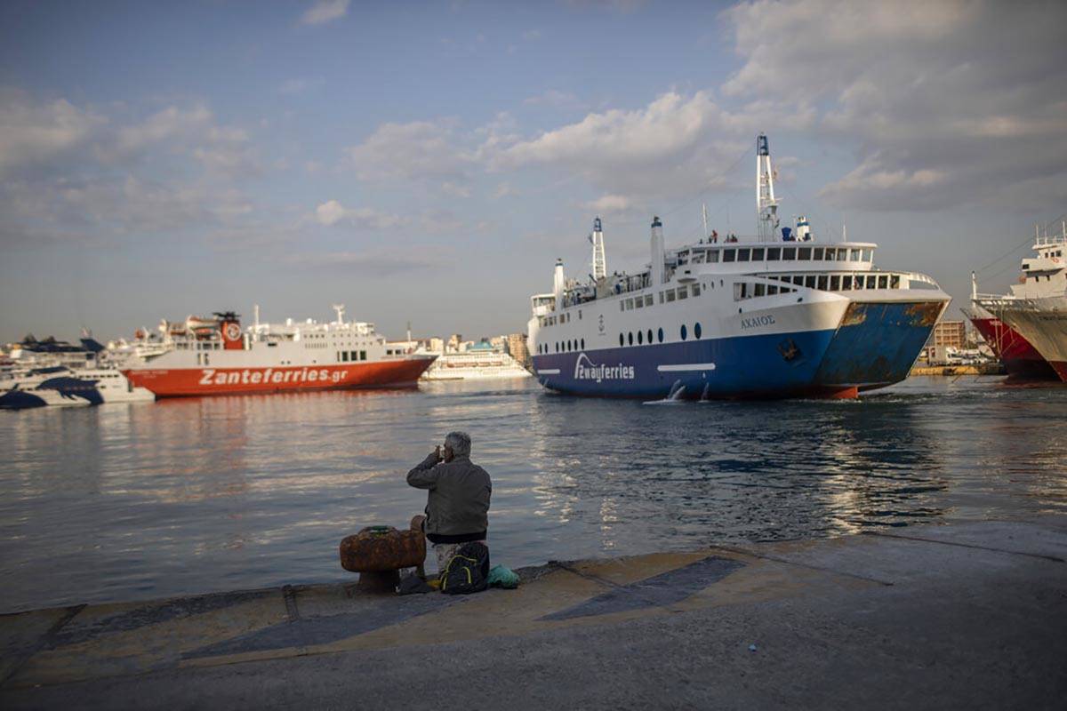 A man sits on the dock at the port of Piraeus, near Athens, on Monday, May 25, 2020. Greece res ...