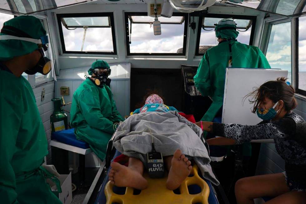 Fluvial emergency workers transfer by boat a 10-year-old suspected COVID-19 patient from a rive ...