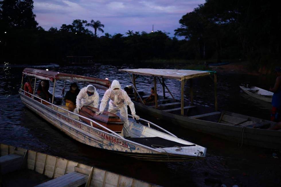 SOS Funeral workers transport by boat a coffin carrying the body of an 86-year-old woman who li ...