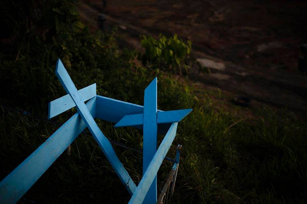 Painted wooden crosses lay on the roadside of a new section of the Nossa Senhora Aparecida ceme ...