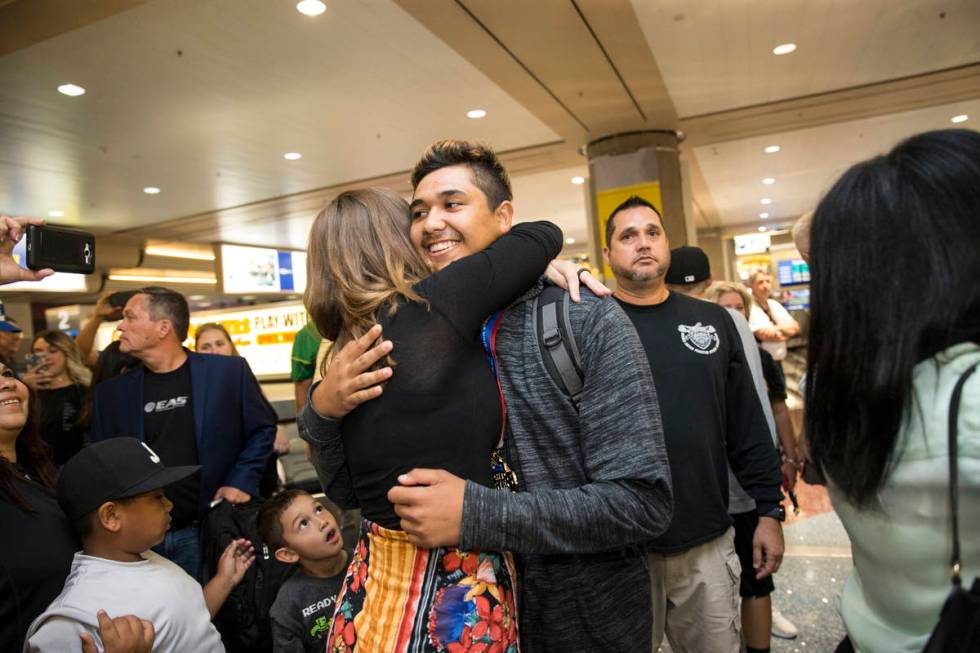 Basic High School students Kianna Jordan, left, 15, hugs Kai Symonds, 17, during his baseball t ...