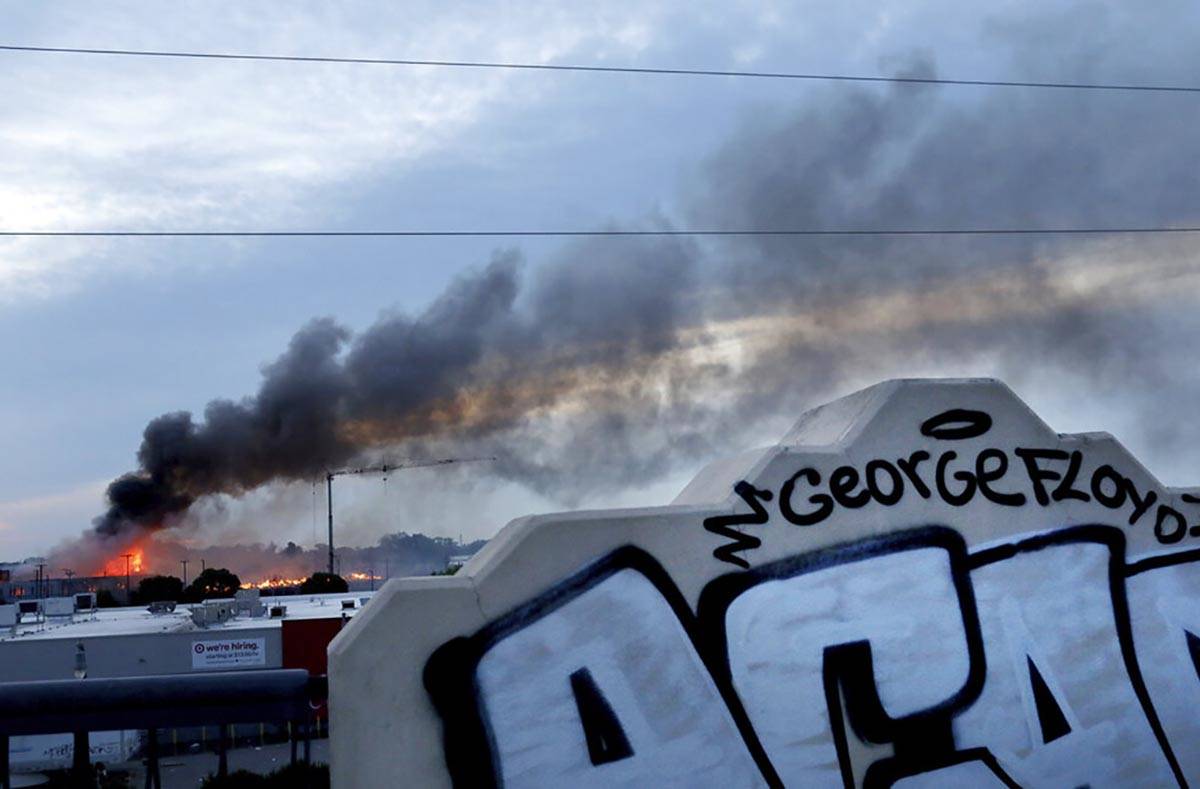 Smoke fills the sky after a night of unrest and protests in the death of George Floyd early Thu ...