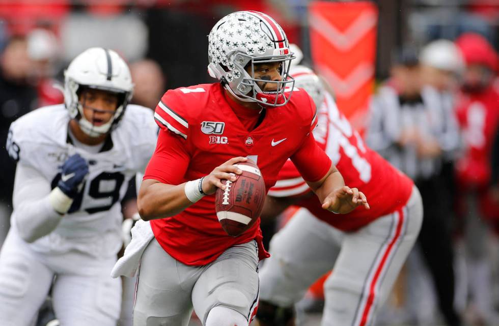 Ohio State quarterback Justin Fields, right, looks for an open receiver as Penn State defensive ...