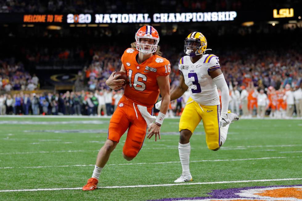 Clemson quarterback Trevor Lawrence scores past LSU safety JaCoby Stevens during the first half ...