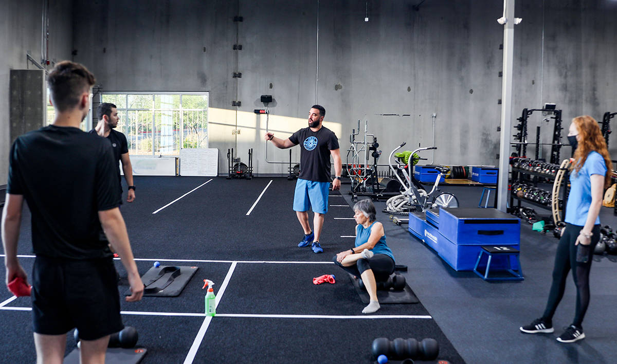 Owner of The Gym Las Vegas Rob Martinez, center, gives strict social distancing instructions to ...