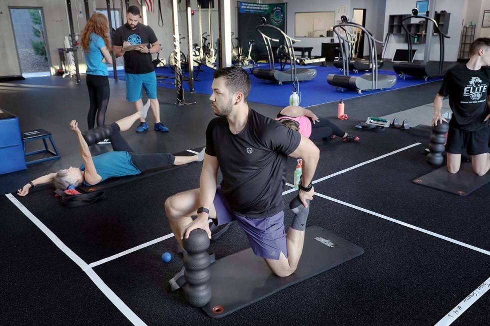 Brian Lee, member of The Gym Las Vegas, stretches while following social distancing guidelines ...