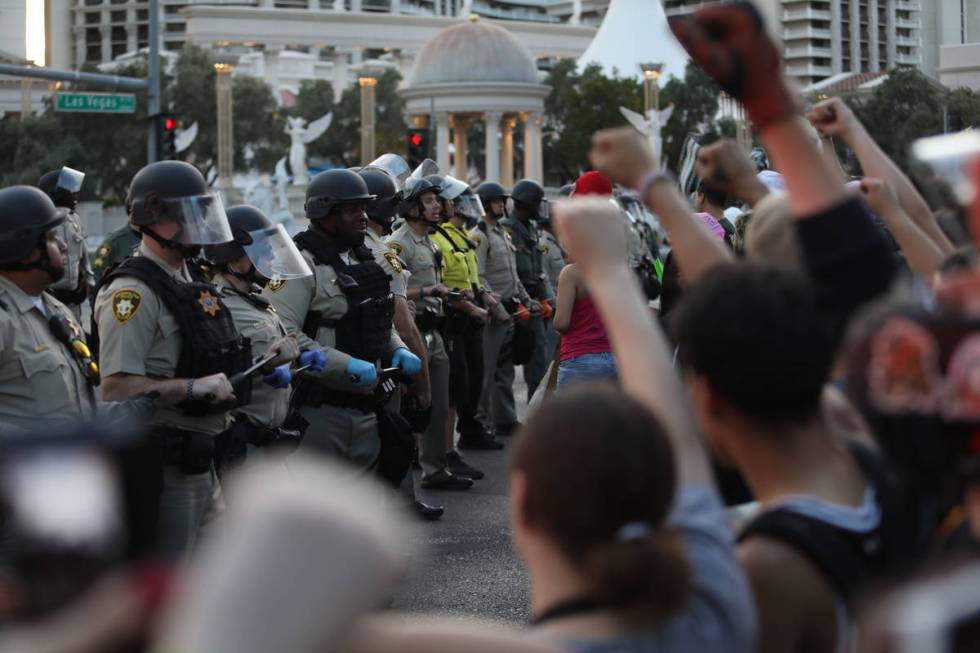 Demonstrators face off against police while demanding justice for George Floyd along the Las Ve ...