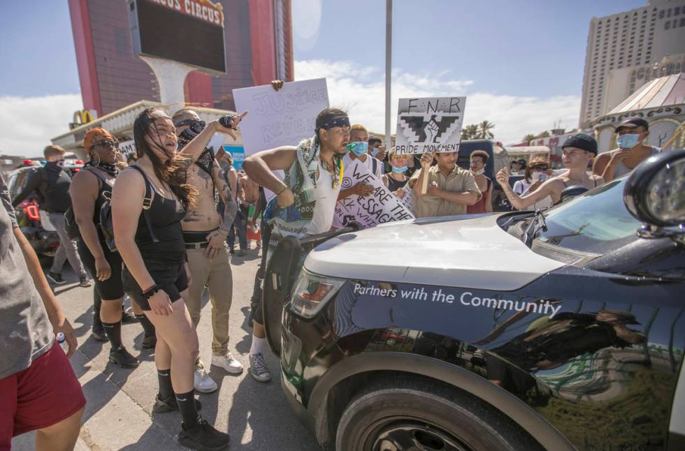 People yell at Las Vegas Police in their vehicle during a Black Lives Matter protest and march ...