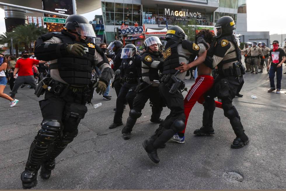 Police arrest a demonstrator as people gather to demand justice for George Floyd along the Las ...