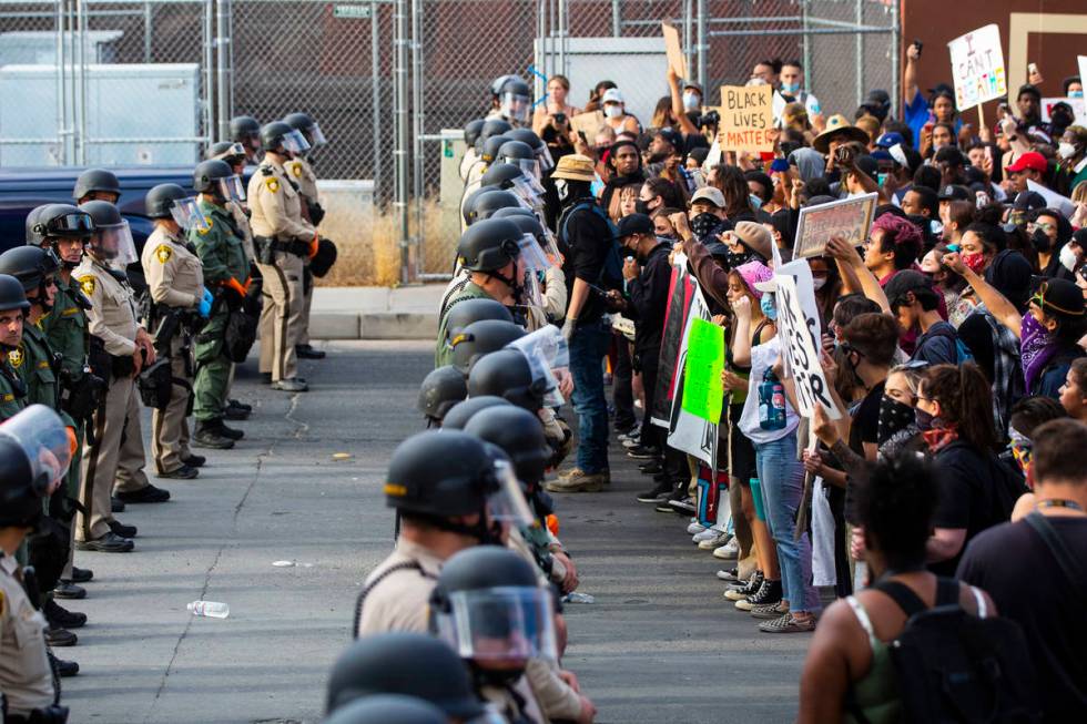 Demonstrators face off against police while demanding justice for George Floyd along the Las Ve ...