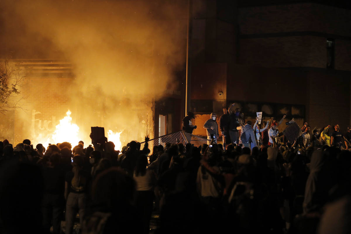 Protesters gather in front of the burning Minneapolis police 3rd Precinct building Thursday, Ma ...