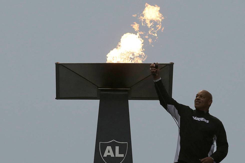 Former NFL football player Greg Townsend lights a ceremonial torch for former Oakland Raiders o ...